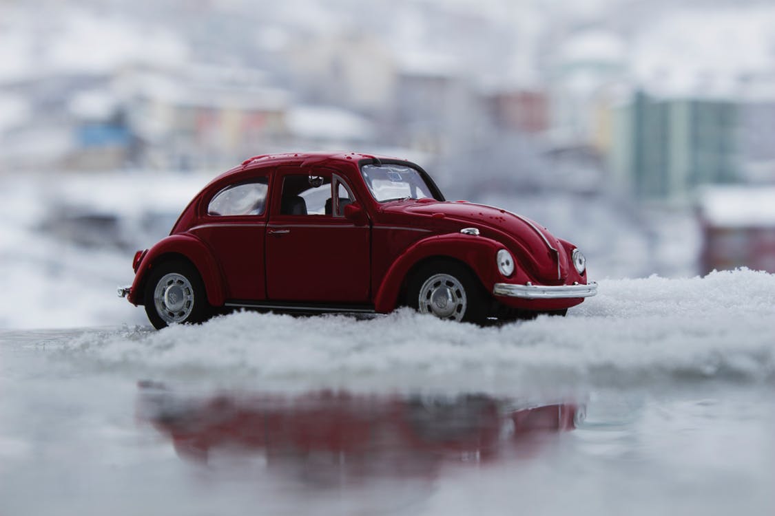 A miniature red car is nestled in snow 