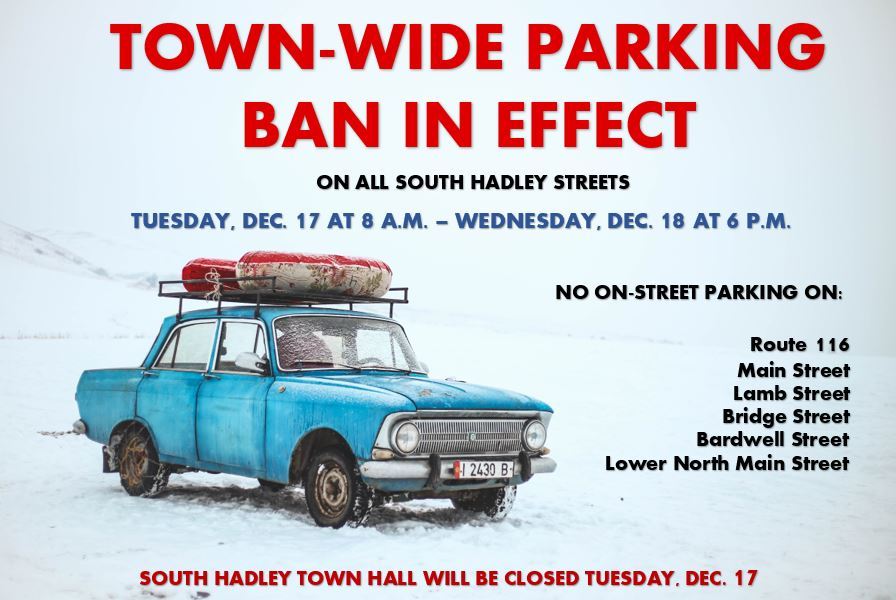 A blue car with a red tube on top is parked on snow