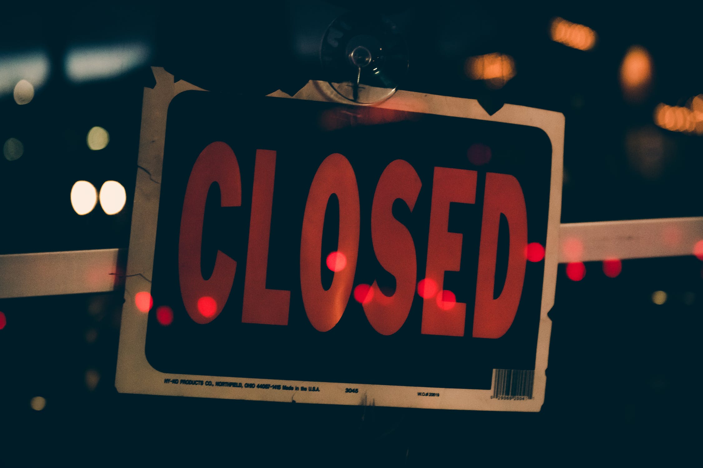 A black sign with orange text that reads closed