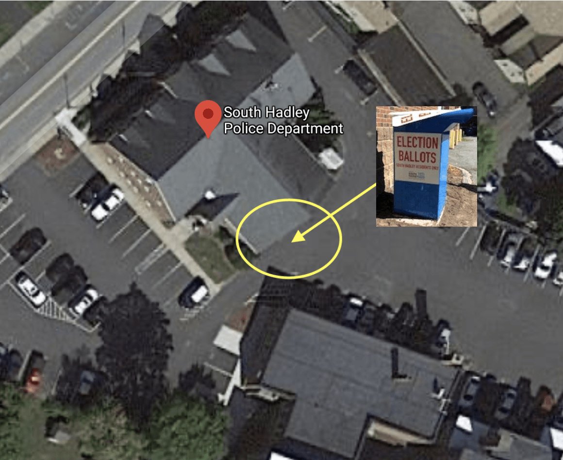 An arial view of parking lots with an arrow marking the ballot box location