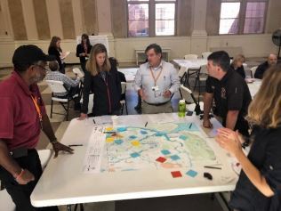 Staff members gather around a table to look at an aerial map