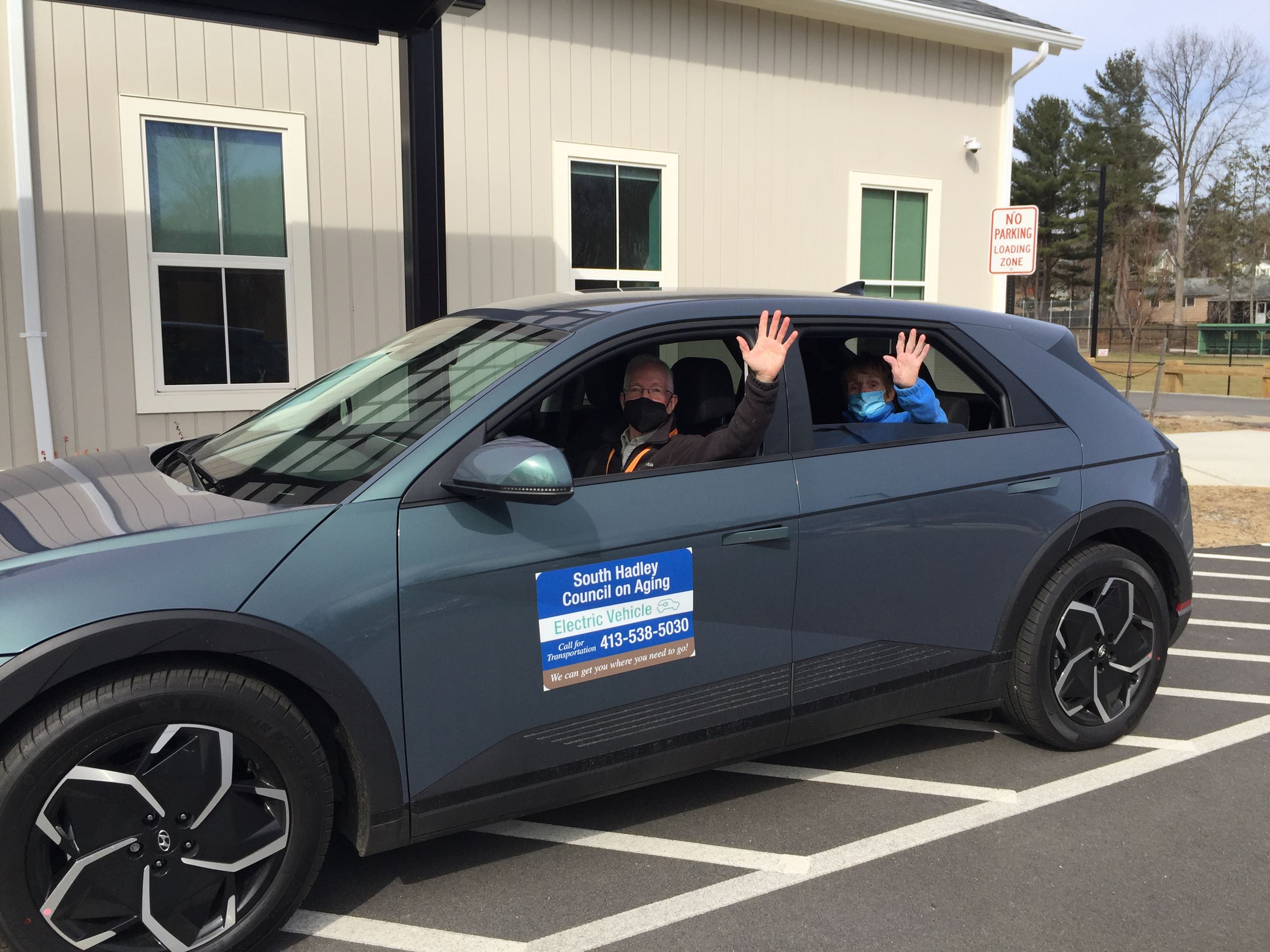 South Hadley COA Van Driver and Passenger Wave Sitting in the New Electric Car